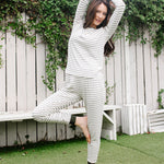 Model in Women’s Ribbed Henley Set in Fir Stripe, standing on one leg with arms overhead.