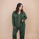 Smiling model looking down to the side while wearing the Women's Long Sleeve Pajama Set in Fir