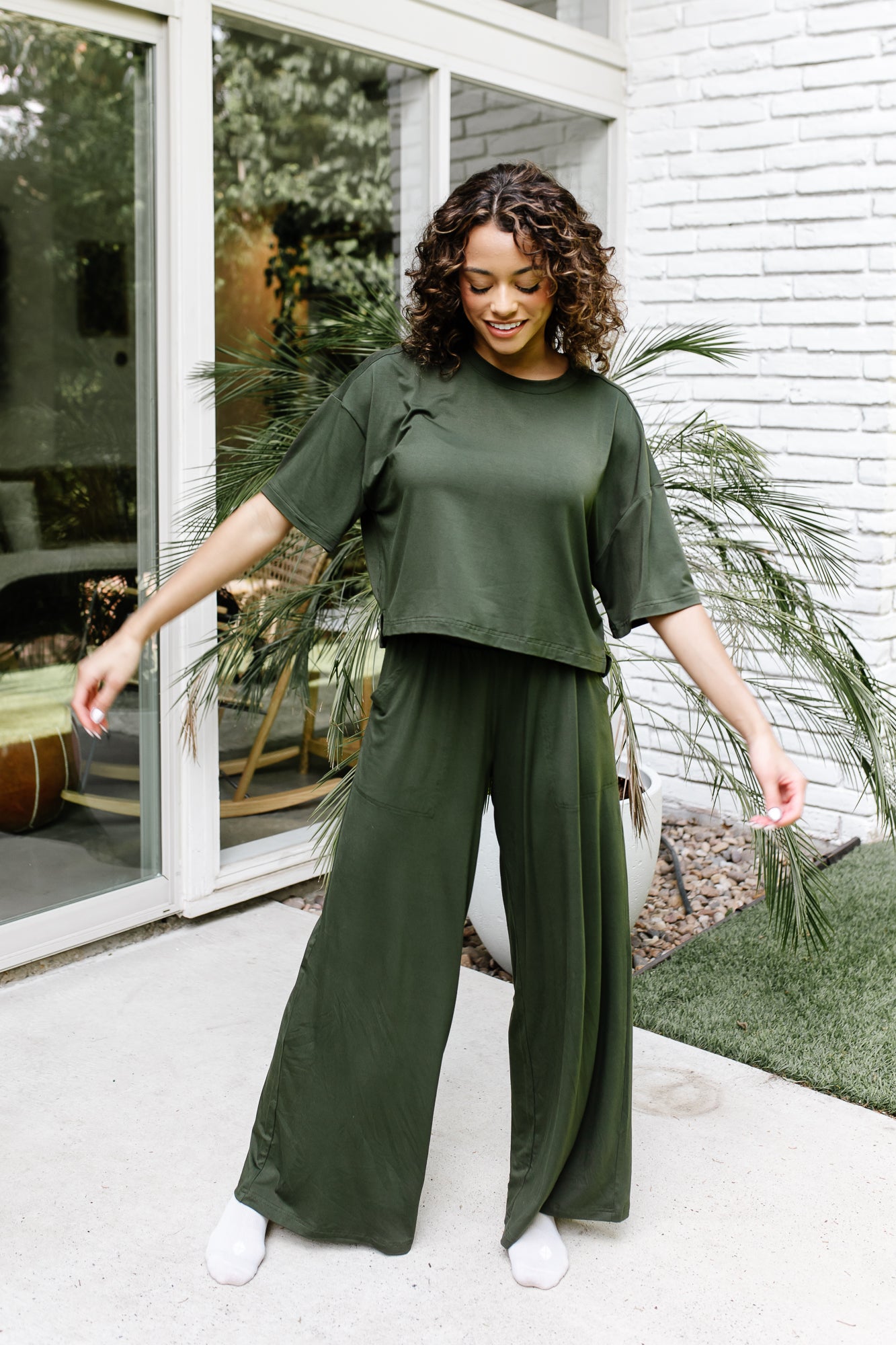 Woman modeling the Kyte Women's Wide Leg Pant in Fir with matching short sleeve tee