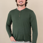 Smiling male model wearing the Kyte Men's Long Sleeve Henley Top in Fir