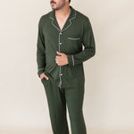 Model standing with one hand on stomach and one in pocket while wearing the Kyte Men's Long Sleeve Pajama Set in Fir