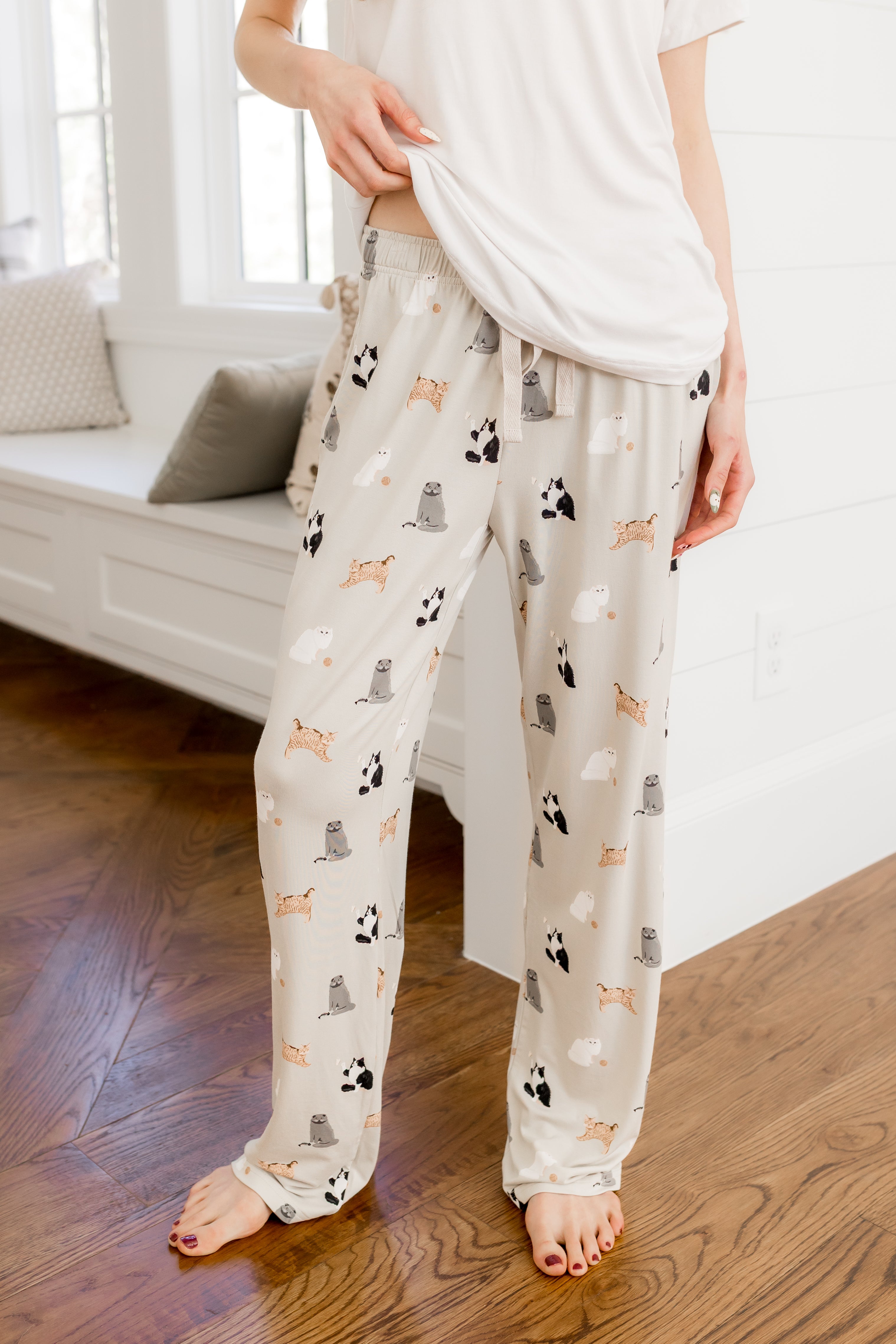Person wearing Women's lounge pant with Fluffy Cat print under a white tee 