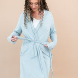 Woman wearing Women’s Lounge Robe in Fog against a beige background. Model showing the adjustable tie functionality
