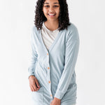 Female modeling the Bamboo Jersey Adult Cardigan in Fog overtop an Oat shirt and oat pants