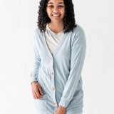 Female modeling the Bamboo Jersey Adult Cardigan in Fog overtop an Oat shirt and oat pants