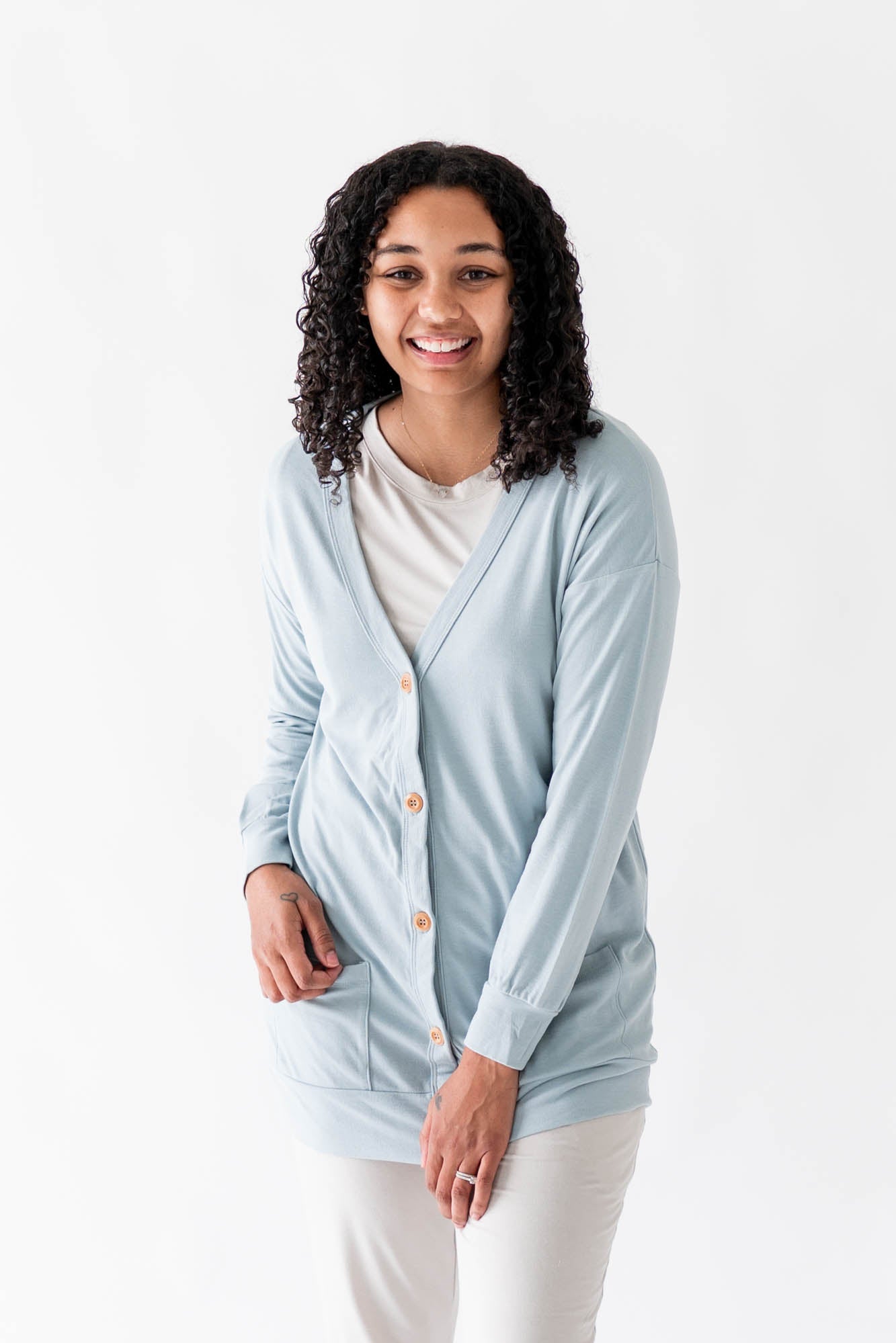 Female modeling the Bamboo Jersey Adult Cardigan in Fog overtop an Oat shirt and oat pants