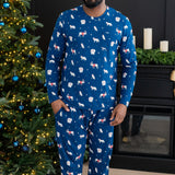 Male modeling blue pajama set with white forest animals print standing in front of a christmas tree 