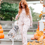 Female model wearing the Long-Sleeved Women's Pajama Set in Gilmore Girls walking her dog down the steps of a gazebo