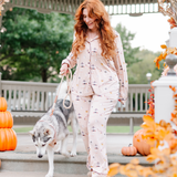 Female model wearing the Long-Sleeved Women's Pajama Set in Gilmore Girls walking her dog down the steps of a gazebo