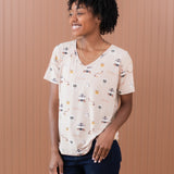 Smiling model looking to the side and wearing the Women's Relaxed Fit V-Neck in Gilmore Girls paired with dark jeans