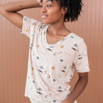 Model looking to the side with one hand in hair while modeling the Kyte Women's Relaxed Fit V-Neck in Gilmore Girls