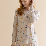 Close up of the top from the Women's Jogger Pajama Set in Gilmore Girls on model who is smiling downwards with one hand in her hair 
