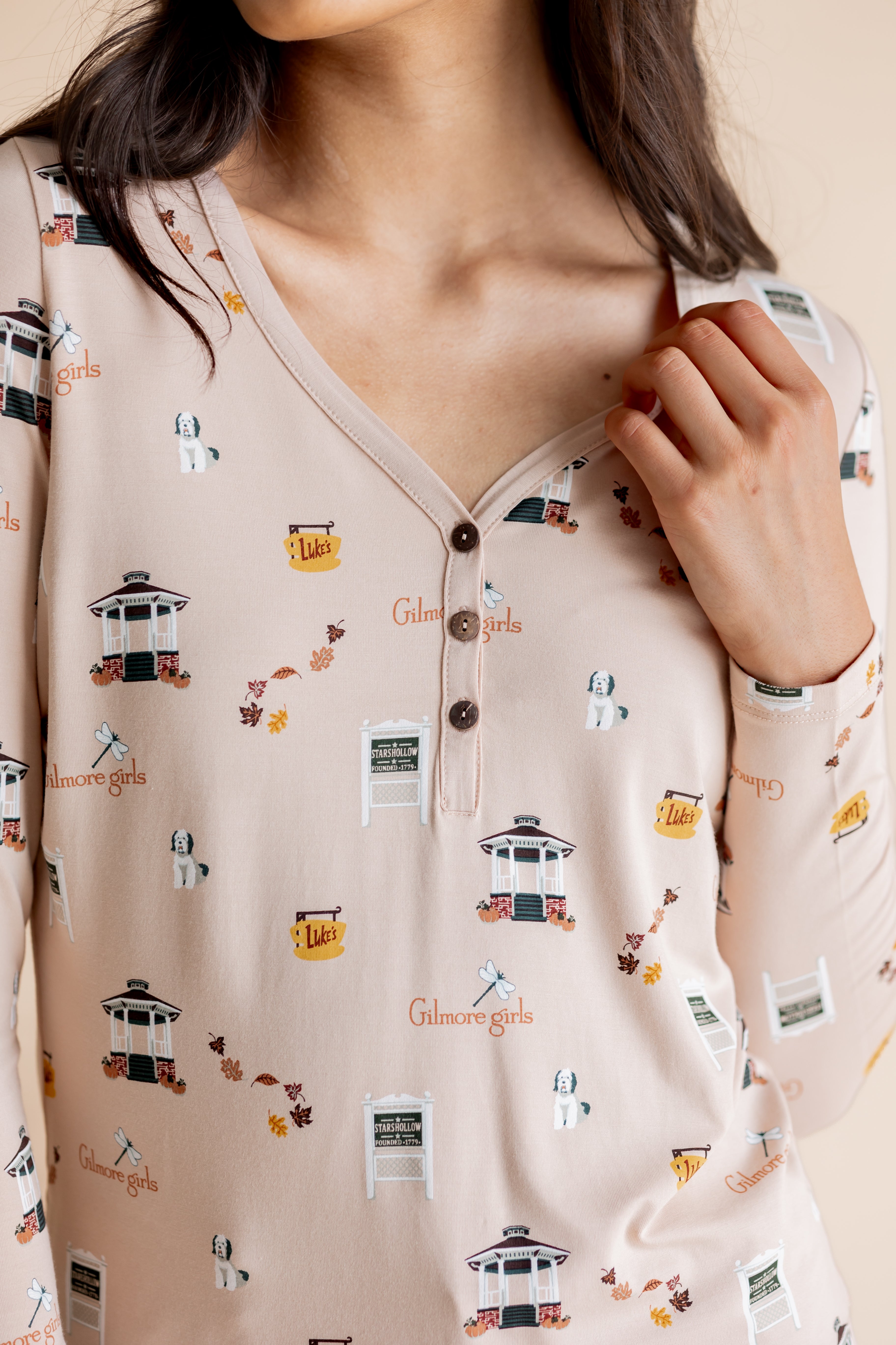 Close up of the Women's Long Sleeve Henley Tee in Gilmore Girls showcasing the buttons and print on a model 