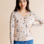 Model with hand on her hip wearing the Women's Long Sleeve Henley Tee in Gilmore Girls while standing in front of a beige background 