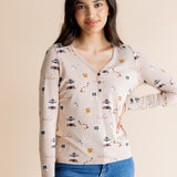 Model with hand on her hip wearing the Women's Long Sleeve Henley Tee in Gilmore Girls while standing in front of a beige background 
