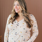 Smiling model looking to the side while wearing the Women's Long Sleeve Henley Tee in Gilmore Girls