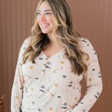 Smiling model looking to the side while wearing the Women's Long Sleeve Henley Tee in Gilmore Girls