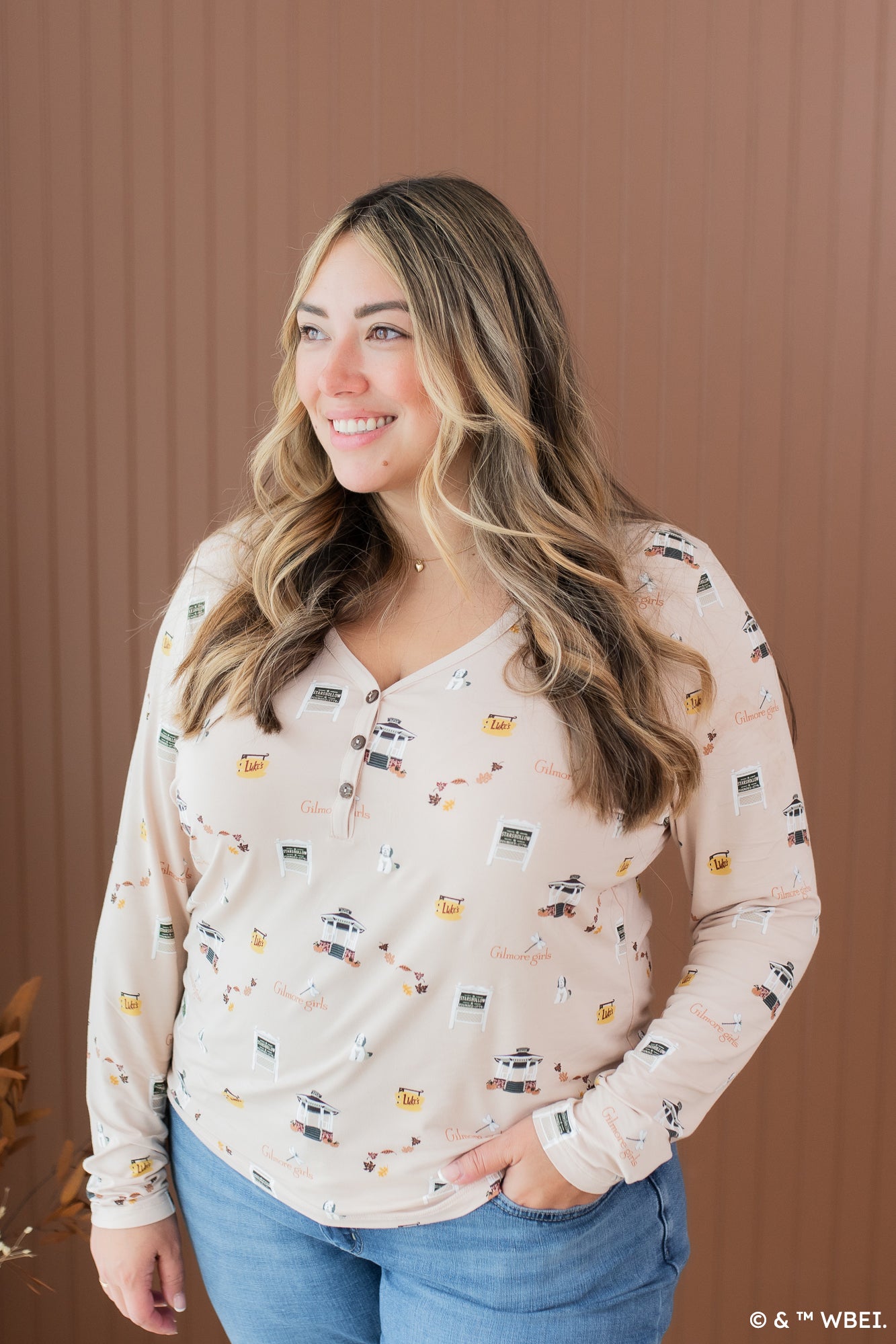 Smiling model looking to the side while wearing the Women's Long Sleeve Henley Tee in Gilmore Girls