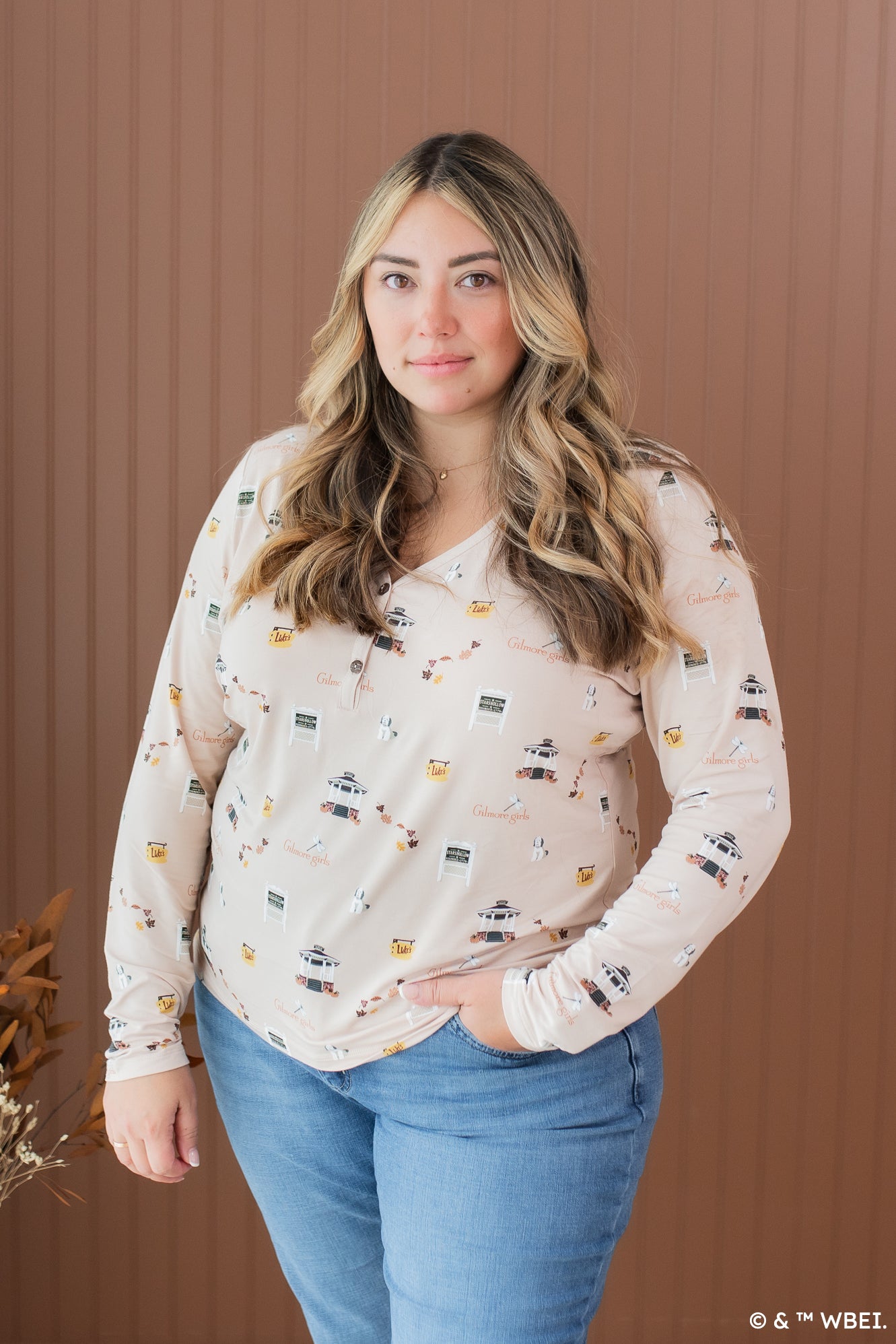 Model wearing the Kyte Women's Long Sleeve Henley Tee in Gilmore Girls paired in light jeans with her hand in her pocket
