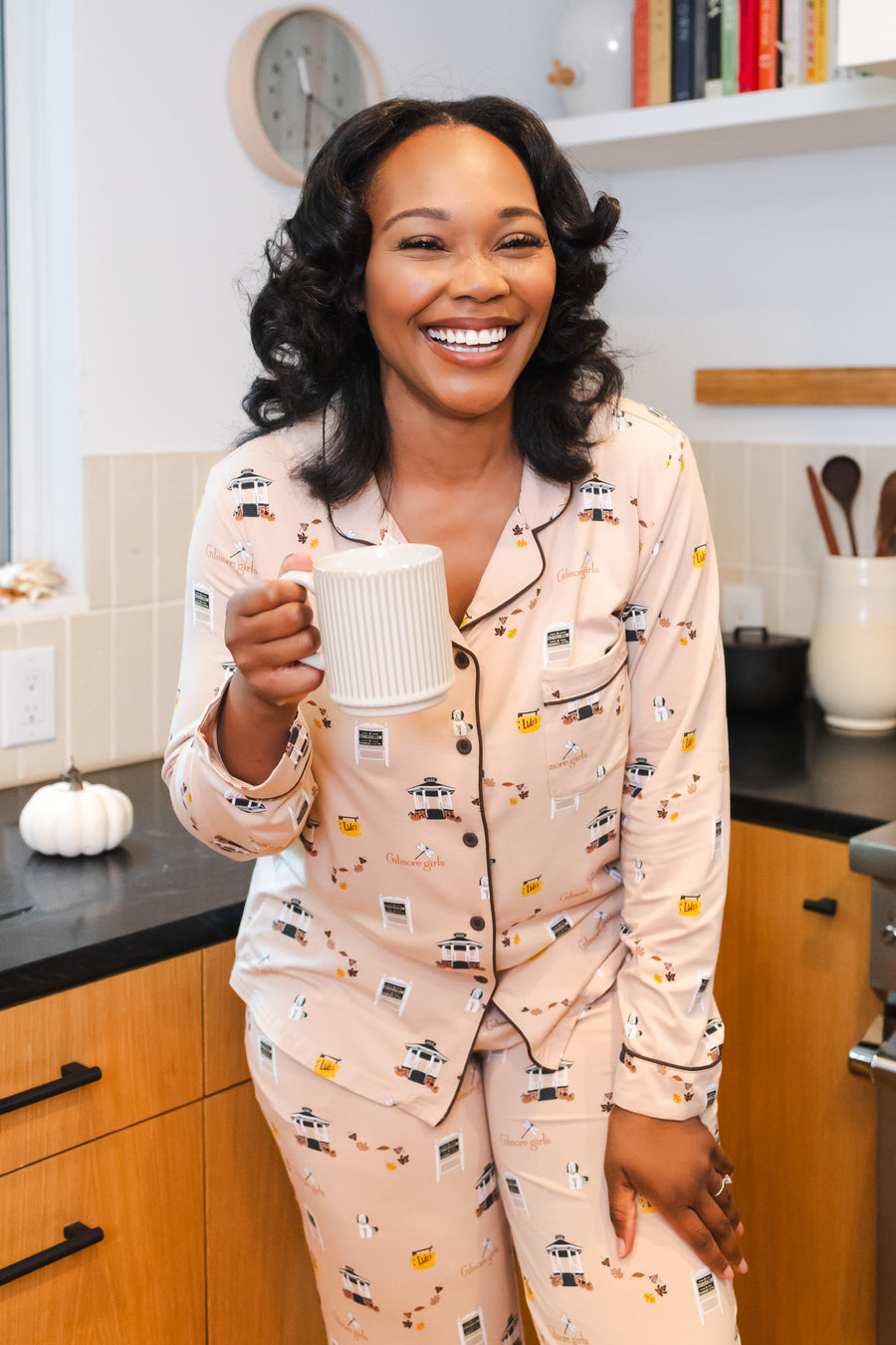 Smiling woman holding a white mug while modeling the Long-Sleeved Women's Pajama Set in Gilmore Girls
