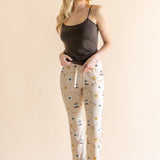Model standing in front of a beige background wearing the Women's Lounge Pants in Gilmore  Girls paired with a coffee cami ::: Model is 5'9" wearing size XS ///
