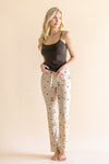 Model standing in front of a beige background wearing the Women's Lounge Pants in Gilmore  Girls paired with a coffee cami ::: Model is 5'9" wearing size XS ///