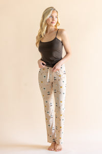 Model standing in front of a beige background wearing the Women's Lounge Pants in Gilmore  Girls paired with a coffee cami