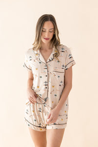 Woman wearing a Gilmore Girls patterned pajama set on a beige background  ::: Model is 5'11" wearing size S ///