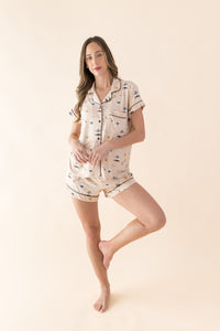 Woman wearing a Gilmore Girls patterned short sleeve pajama set on a beige background