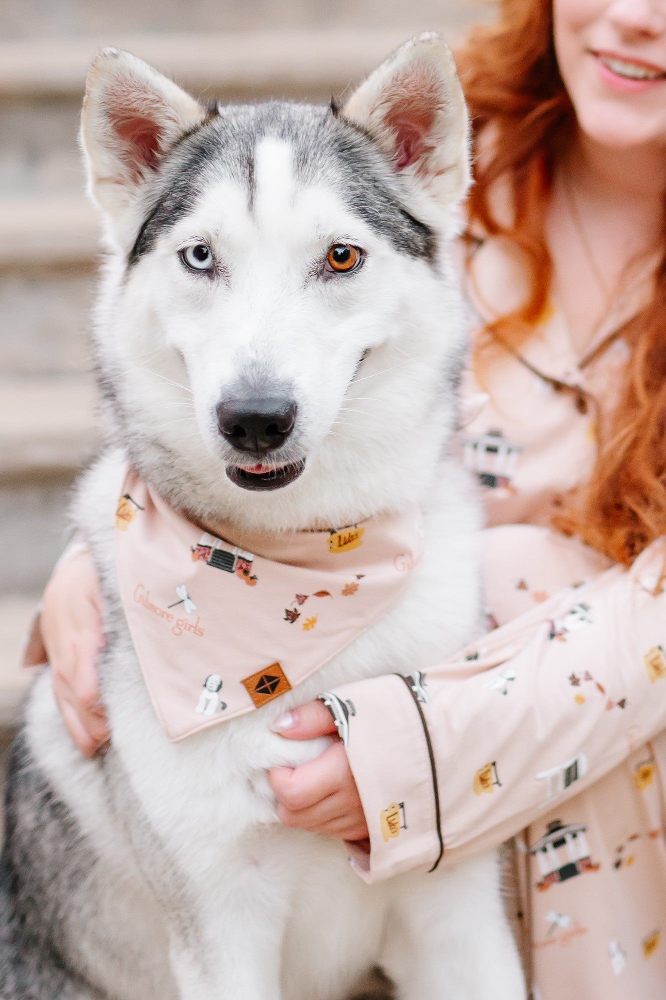 Female model wearing the long sleeve women's pajama set in gilmore girls sitting on stairs beside a husky wearing the Dog Bandana in Gilmore Girls