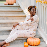 Woman sitting on concrete stairs next to a pumpkin while modeling the Women's Jogger Pajama Set in Gilmore Girls