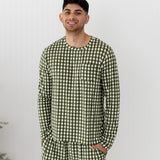Man wearing green checkered pajamas against a white background