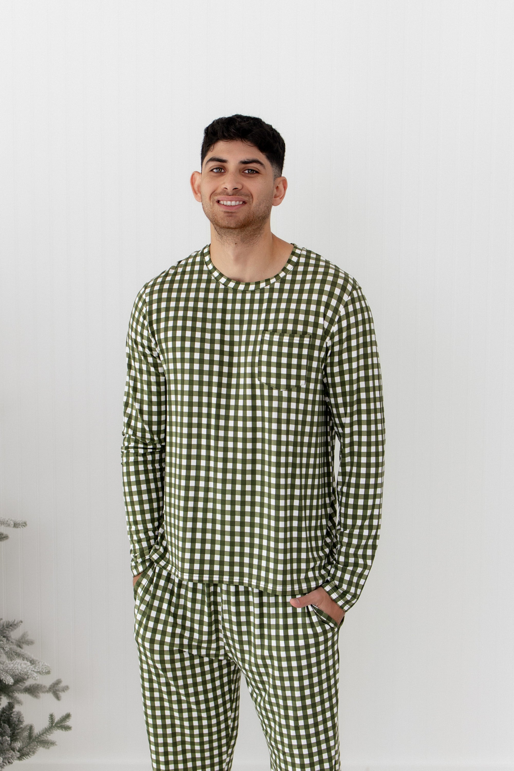 Man wearing green checkered pajamas against a white background