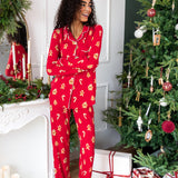Woman standing with her arms crossed looking to the side laughing in long sleeve pajama set in gingerbread print

---1605 3