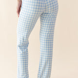 Light blue gingham check pants worn by a person on a beige background