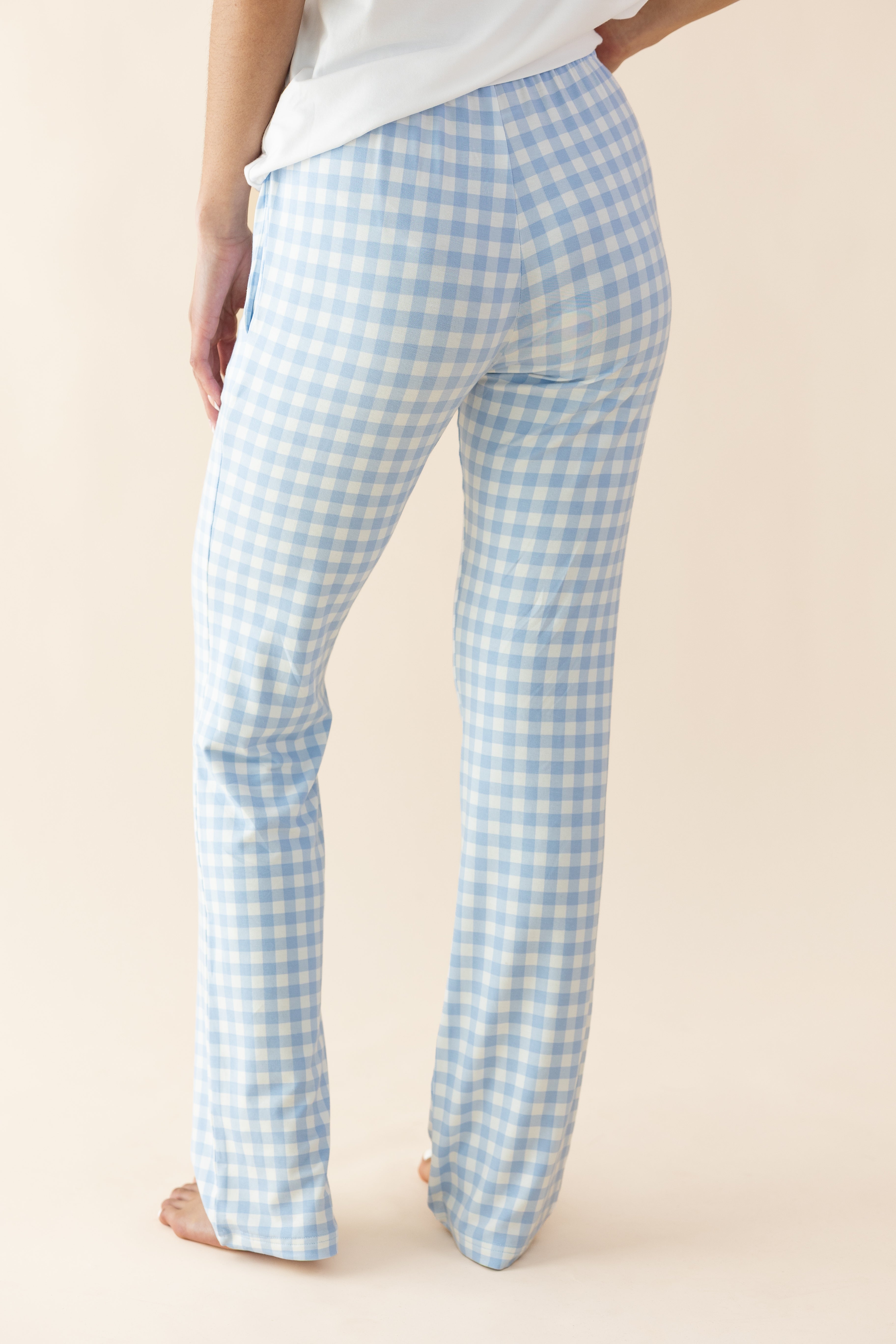 Light blue gingham check pants worn by a person on a beige background