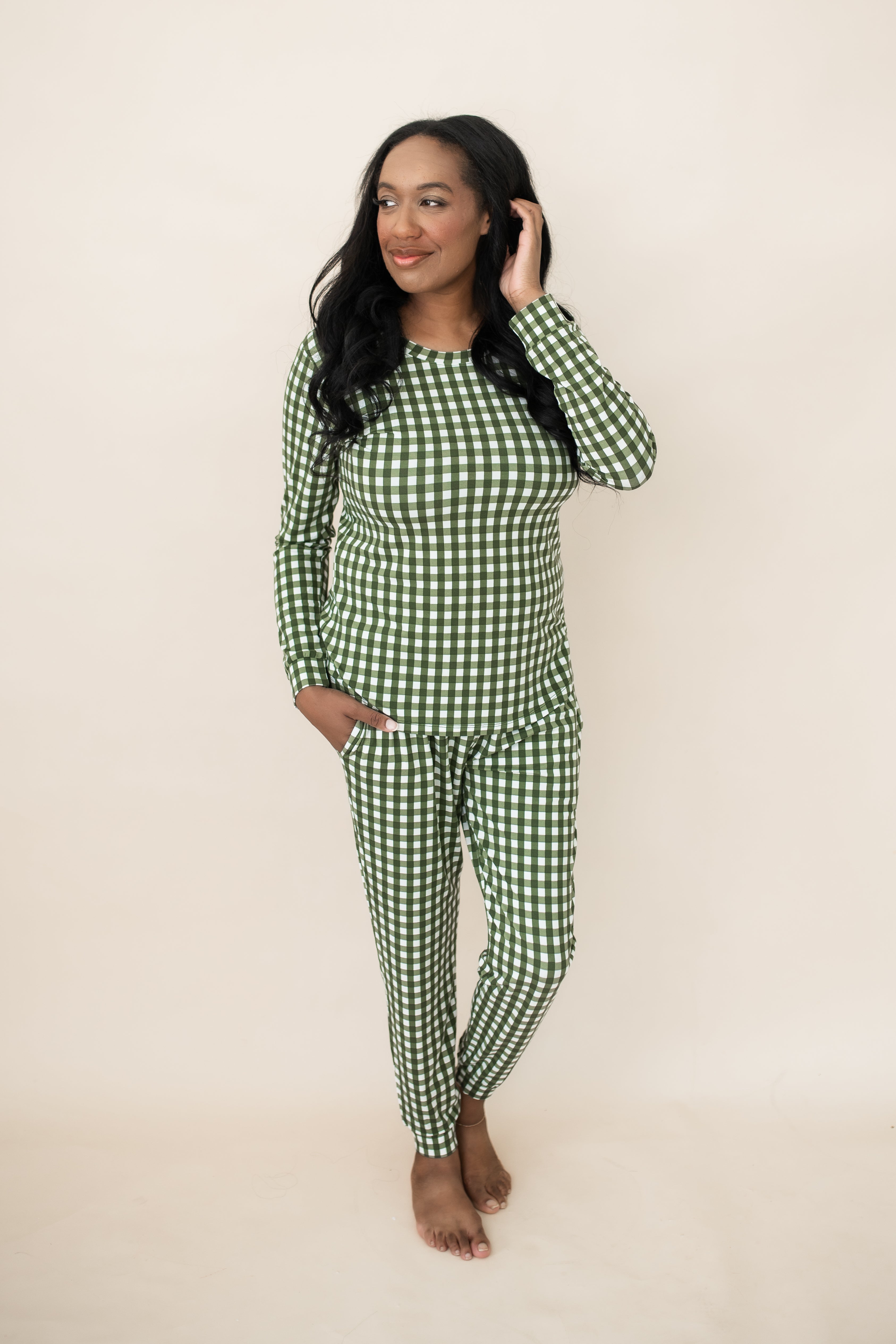 Model standing in front of a beige wall wearing the Bamboo Women's Jogger Pajama Set in Gingham Fir