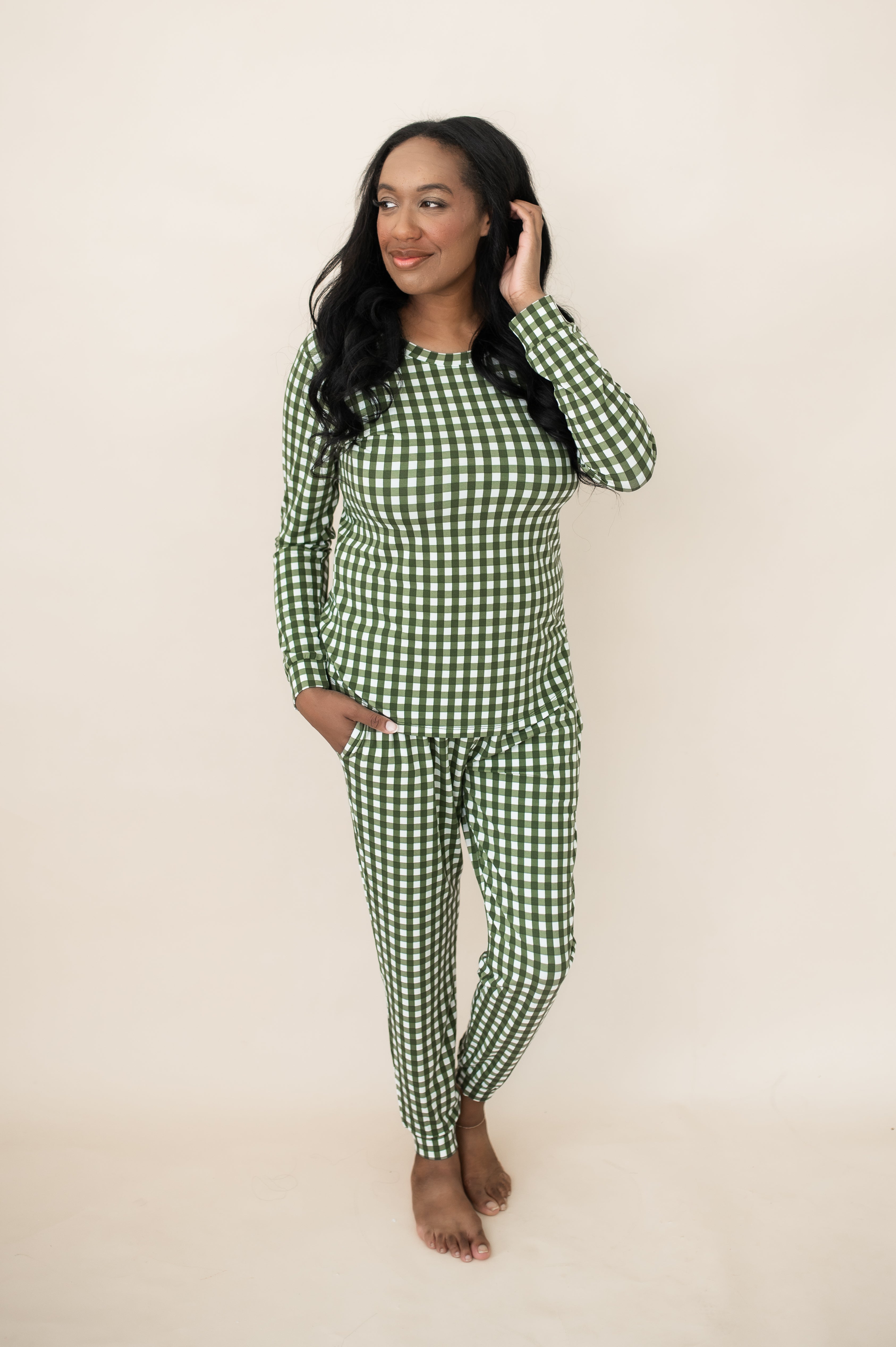 Model standing in front of a beige wall wearing the Bamboo Women's Jogger Pajama Set in Gingham Fir