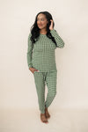 Model standing in front of a beige wall wearing the Bamboo Women's Jogger Pajama Set in Gingham Fir