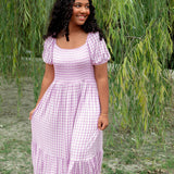 Women’s Smocked Dress in a light purple checkered pattern in an outdoor setting