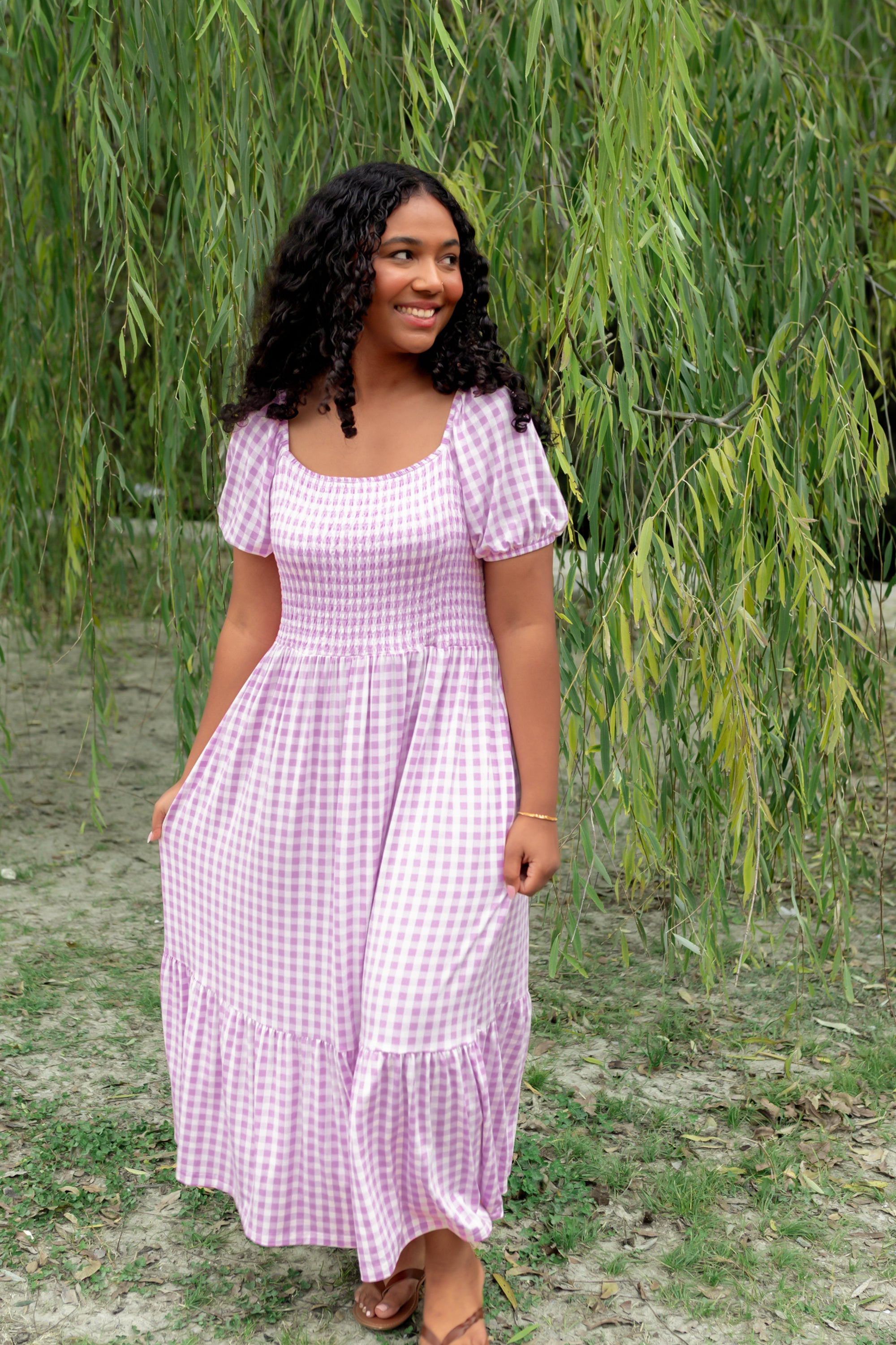 Women’s Smocked Dress in a light purple checkered pattern in an outdoor setting