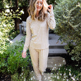 Model standing in greenery while wearing the Women's Jogger Set in Gingham Bisque