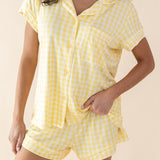 Woman wearing a yellow checkered pajama set against a beige background