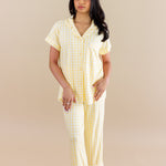 Woman wearing a yellow checkered pajamas against a beige background   ::: Model is 5' wearing size XS ///