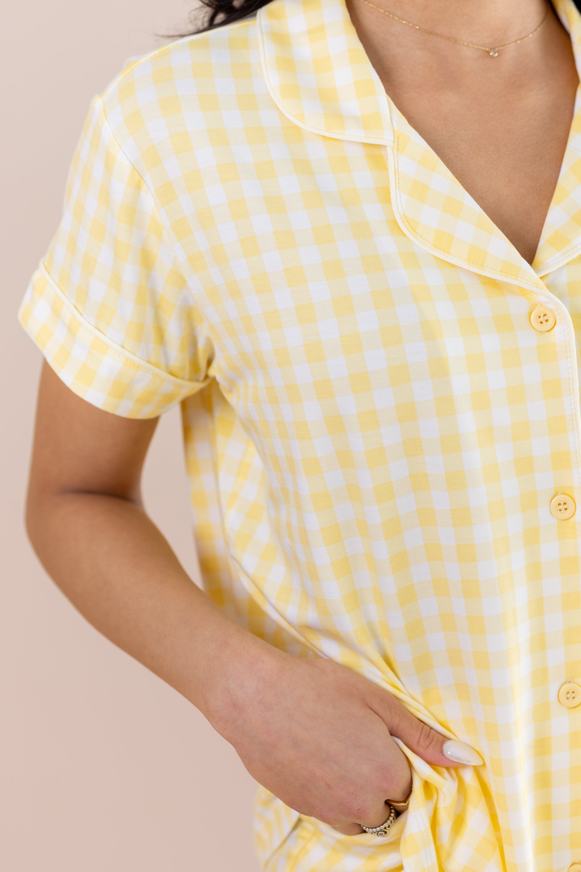 Yellow checkered pajama shirt worn by a person on a beige background