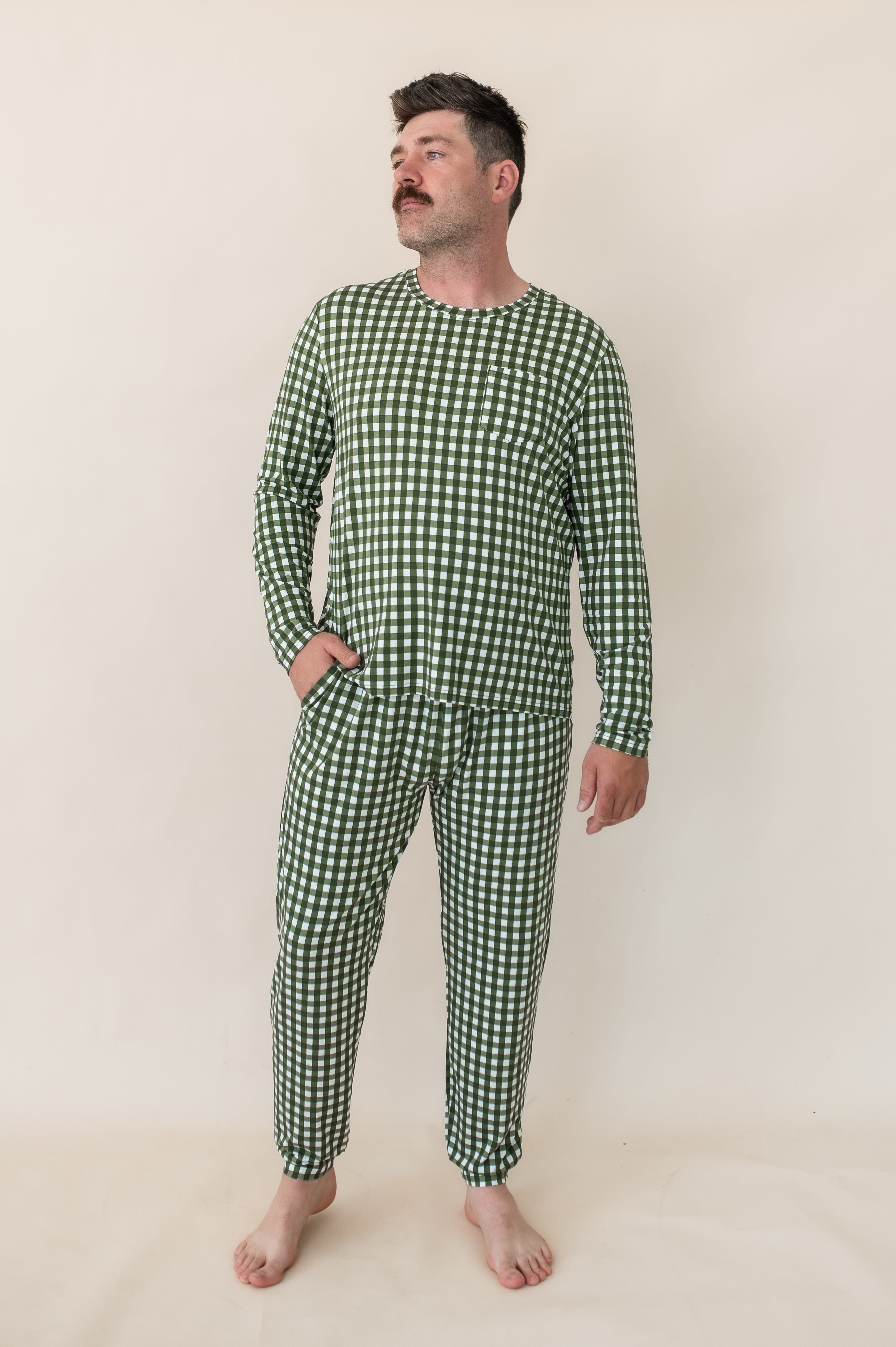 Model looking to the side with one hand in pocket while wearing the Bamboo Men's Jogger Set in Gingham Fir