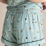 Model showing the back of Women's Short Sleeve Pajama Set shorts in Golf print on beige background