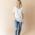 Smiling female model posing wearing the Women's Relaxed Fit V-Neck in Grogu™ with medium wash jeans
