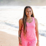 Female model on the beach wearing the Women’s Tank Set in Guava
