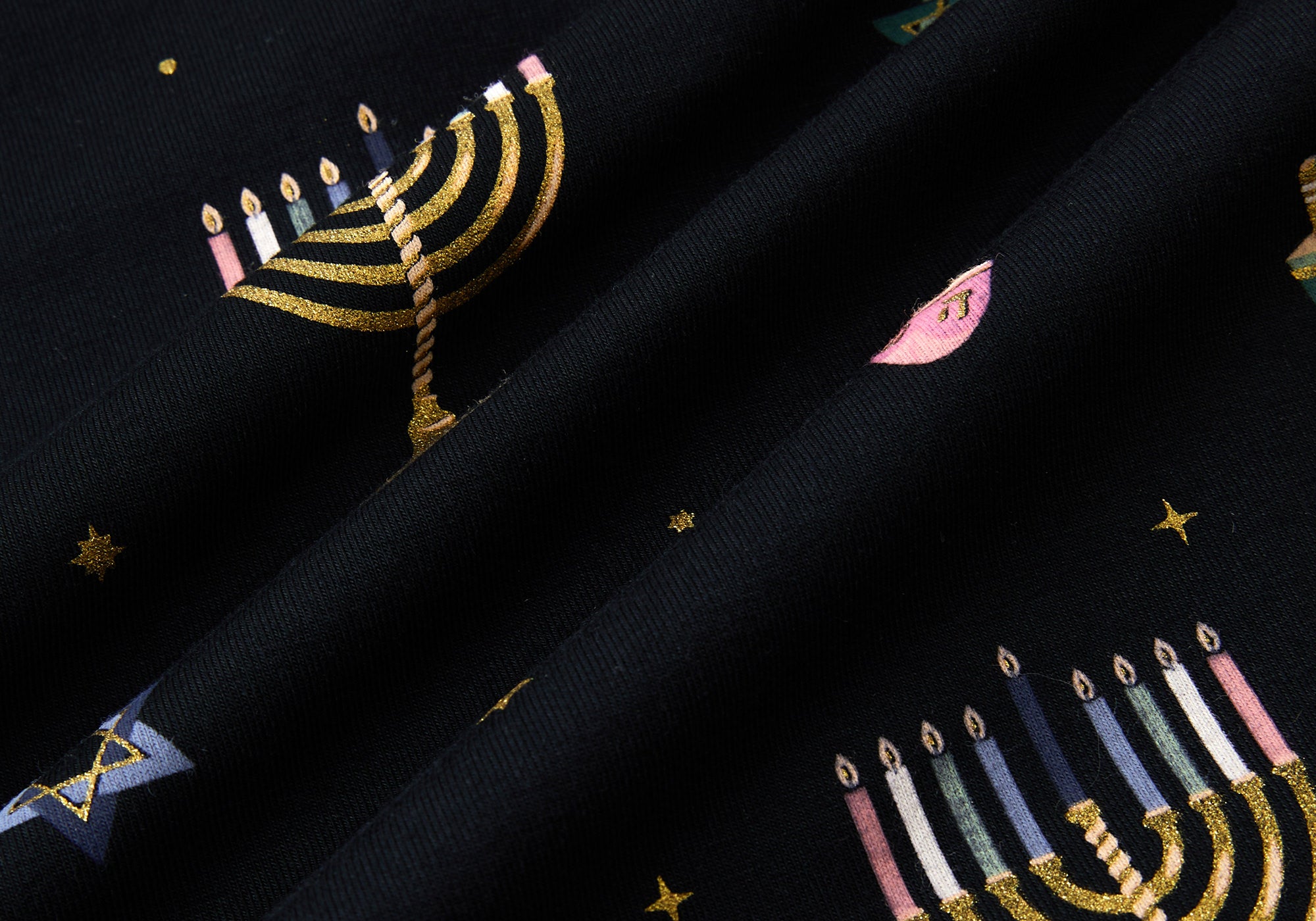 Black fabric with Hanukkah elements printed 